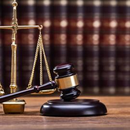 Ζυγαριά δικαιοσύνης και σφύρα δικαστηρίου μπροστά σε νομικά βιβλία Ζυγαριά δικαιοσύνης ξύλινη σφύρα